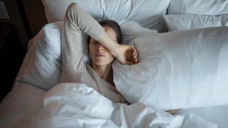 Young woman waking up and feeling tired (suffering from insomnia).