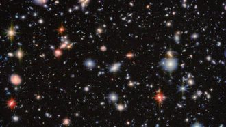 This image from the NASA/ESA/CSA James Webb Space Telescope revisits one of the most iconic regions of the sky, the Hubble Ultra Deep Field, through the eyes of two of Webb’s instruments. The result is a detailed view that reveals thousands of distant galaxies, some dating back to the earliest periods of cosmic history.The field shown here, known as the MIRI Deep Imaging Survey (MIDIS) region, was observed with the three shortest-wavelength filters of Webb’s Mid-Infrared Instrument (MIRI) for nearly 100 hours in total. This included Webb's longest observation of an extragalactic field in one filter so far, producing one of the deepest views ever obtained of the Universe. Combined with data from Webb’s Near-Infrared Camera (NIRCam), this image allows astronomers to explore how galaxies formed and evolved over billions of years. These deep observations have revealed more than 2500 sources in this tiny patch of sky. Among them are hundreds of extremely red galaxies — some of which are likely massive, dust-obscured systems or evolved galaxies with mature stars that formed early in the Universe’s history. Thanks to Webb’s sharp resolution, even at mid-infrared wavelengths, researchers can resolve the structures of many of these galaxies and study how their light is distributed, shedding light on their growth and evolution. In this image, the colours that have been assigned to different kinds of infrared light highlight the fine distinctions astronomers can make with this deep data. Orange and red represent the longest mid-infrared wavelengths. The galaxies in these colours have extra features — such as high concentrations of dust, copious star formation, or an active galactic nucleus (AGN) at their centre — which emit more of this farther infrared light. Small, greenish-white galaxies are particularly distant, with high redshift. This shifts their light spectrum into the peak mid-infrared wavelengths of the data, which are depicted in white and green. Most of the galaxies in this image lack any such mid-infrared boosting features, leaving them most bright at shorter near-infrared wavelengths, which are depicted with blue and cyan colours. By returning to this legacy field first made famous by the NASA/ESA Hubble Space Telescope, Webb is continuing and expanding the deep field tradition — revealing new details, uncovering previously hidden galaxies, and offering fresh insights into the formation of the first cosmic structures. The MIRI observations were taken as part of the Webb programmes #1283 and #6511 (PI: G. Östlin). [Image Description: An area of deep space with thousands of galaxies in various shapes and sizes on a black background. Most are circles or ovals, with a few spirals. More distant galaxies are smaller, down to being mere dots, while closer galaxies are larger and some appear to be glowing. Red and orange galaxies contain more dust or more stellar activity.] Links  Science paper (G. Östlin et al.) Slider Tool Pan Video Transition video (with Hubble Ultra Deep Field)