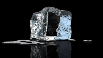 Single ice cube melting on a black reflective surface
