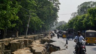 TOPSHOT - Motorists make their way past a large crack in the ground along Myo Patt Road linking Mandalay and Sagaing Township on the outskirts of Mandalay on April 2, 2025, five days after a major earthquake struck central Myanmar. The shallow 7.7-magnitude earthquake on March 28 flattened buildings across Myanmar, killing nearly 3,000 people and making thousands more homeless. (Photo by Sai Aung MAIN / AFP) (Photo by SAI AUNG MAIN/AFP via Getty Images)